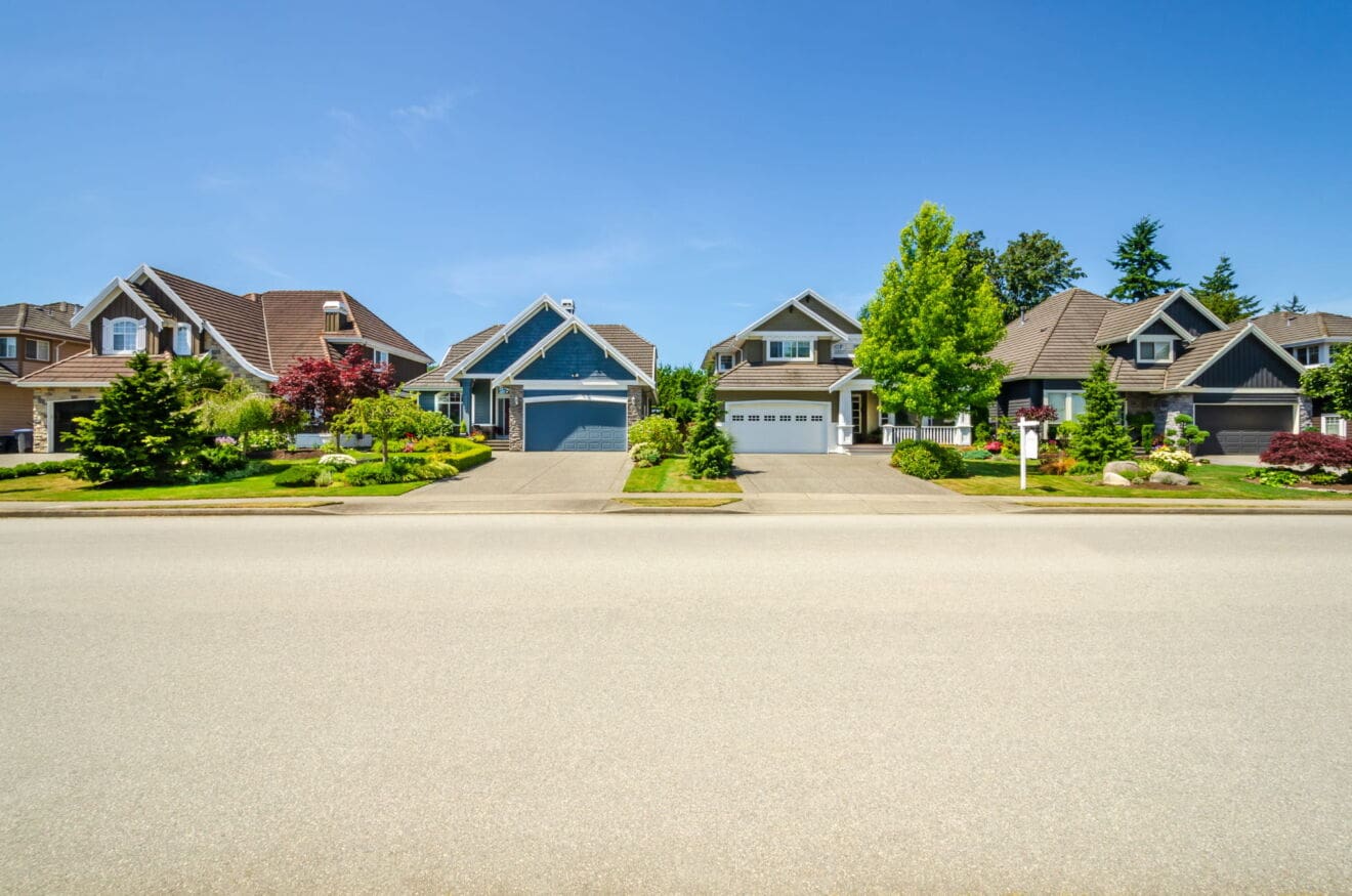 Detached homes with garages and landscaped front yards, illustrating neighbourhood choices when moving to Hamilton.