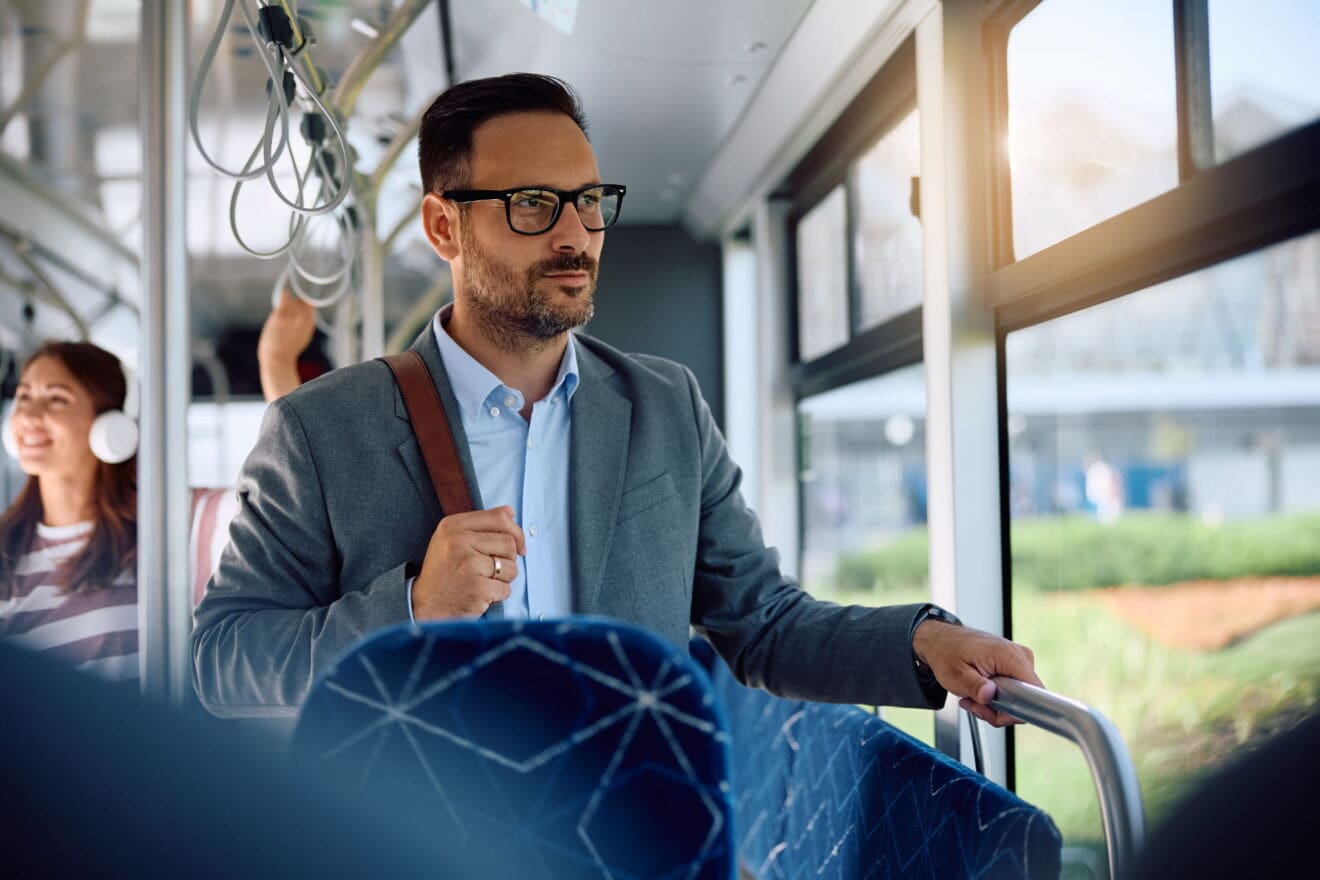 Passenger standing inside a public transit vehicle, illustrating commuting considerations when moving to Hamilton.